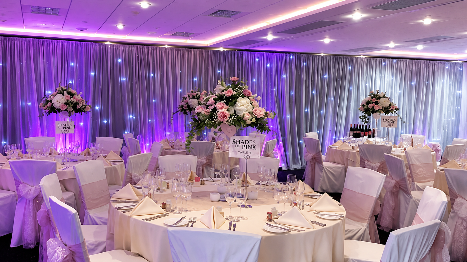 Wedding room with white voile draping & uplighting
